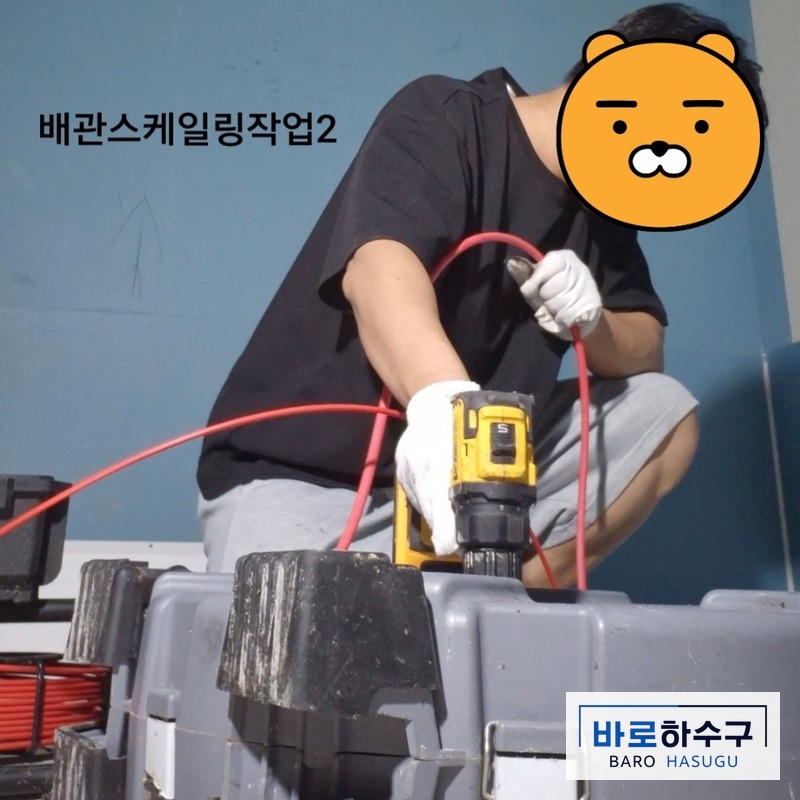 스케일링 케이블을 손으로 잡고 안양 식당 배관에 밀어 넣는 작업자